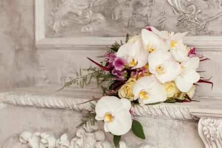 Orchid bridal bouquet in ancient stone wall setting