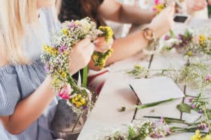 Girls making floral crowns at flower bar