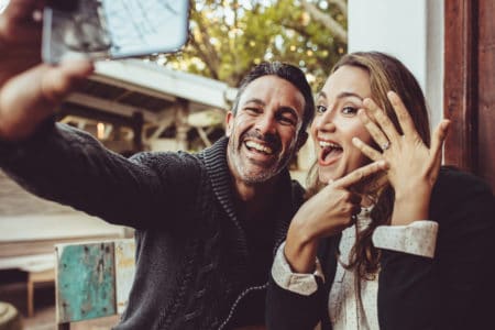 Woman pointing to engagement ring with finance taking a photo