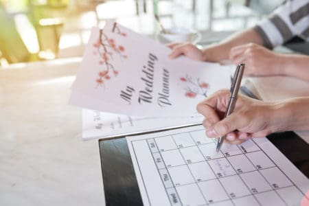 Couple holding wedding planning calendar