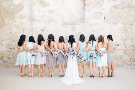 Bridesmaids standing in a line wearing different dresses