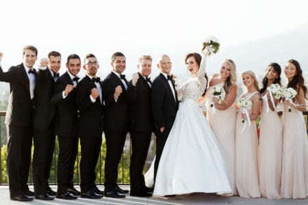 Wedding party in classic black tuxedos and long blush dresses