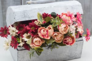 Pink and red flowers inside an antique suitcase