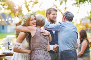 Guests huggin bride and groom at wedding