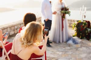 Wedding guest using their phone to take photos of ceremony