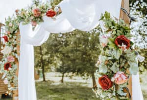 Decorating the arch with flowers and fabric for a wedding ceremony in nature