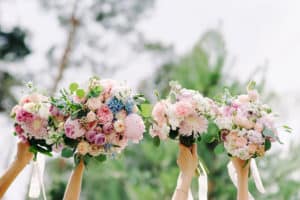 Bridesmaids holding wedding bouquets in the air