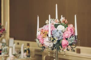 beautiful hydrangea bouquets in vases and shiny silver candelabras with candles on tables at luxury wedding reception in restaurant. stylish decor and adorning