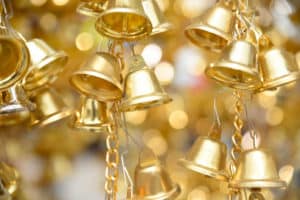 Close up group of shiny golden small bells with blur bokeh background, selective focus