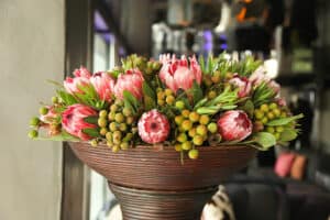 Tall floral arrangement with greenery and protea