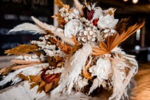 Boho Wedding Style with Orange boho flowers and gold wedding cake, fall wedding style with macrame touch. Gorgeous wedding decor and table set up. Flat Lay stationary. Grand Cake Stand